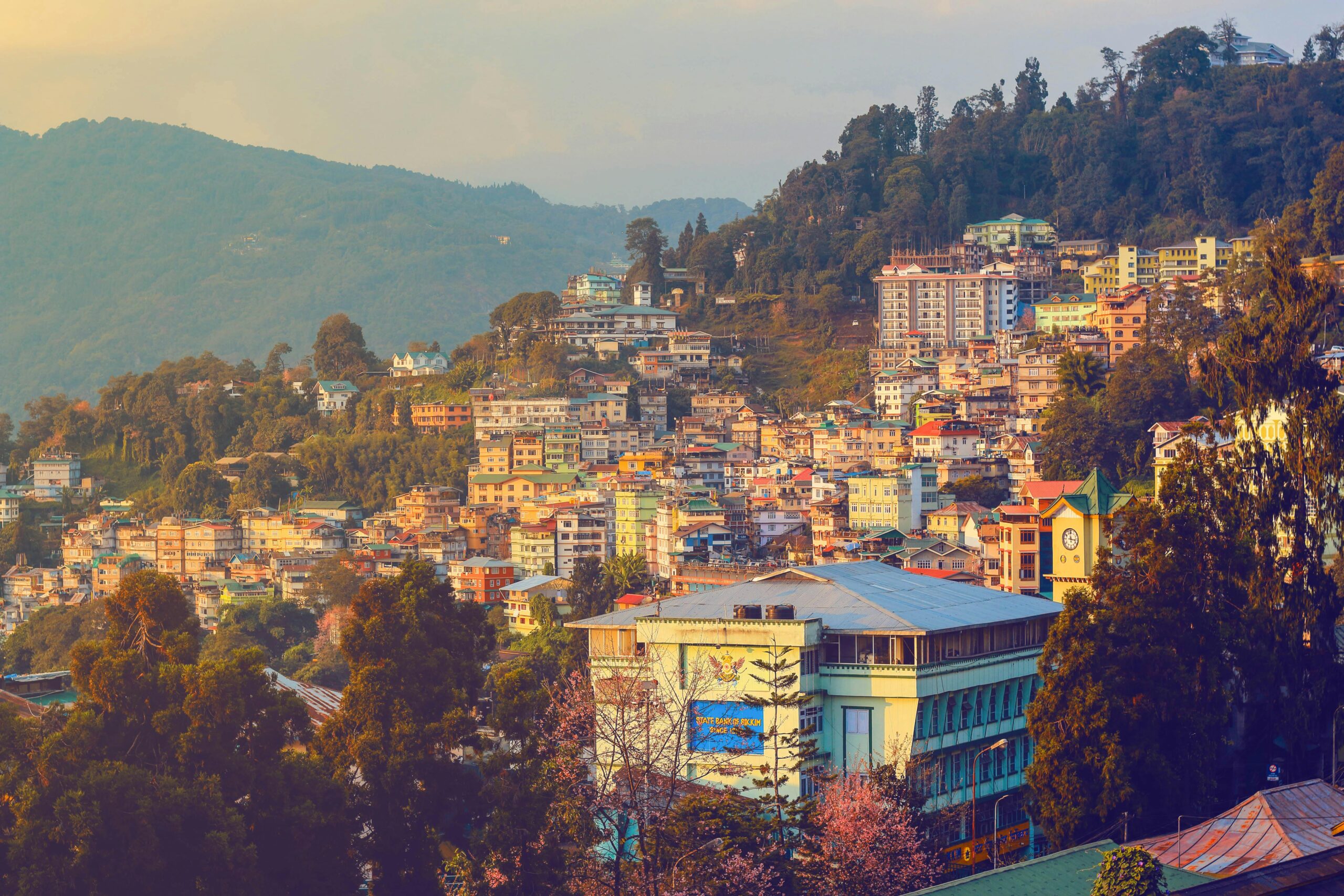 Stunning view of Gangtok, Sikkim at sunset showcasing vibrant urban landscape and scenic hills.