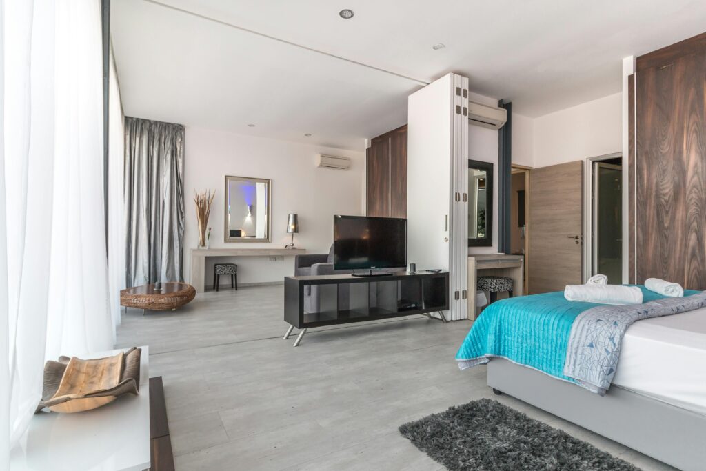 Spacious and modern bedroom with sleek design, featuring elegant decor and natural lighting.