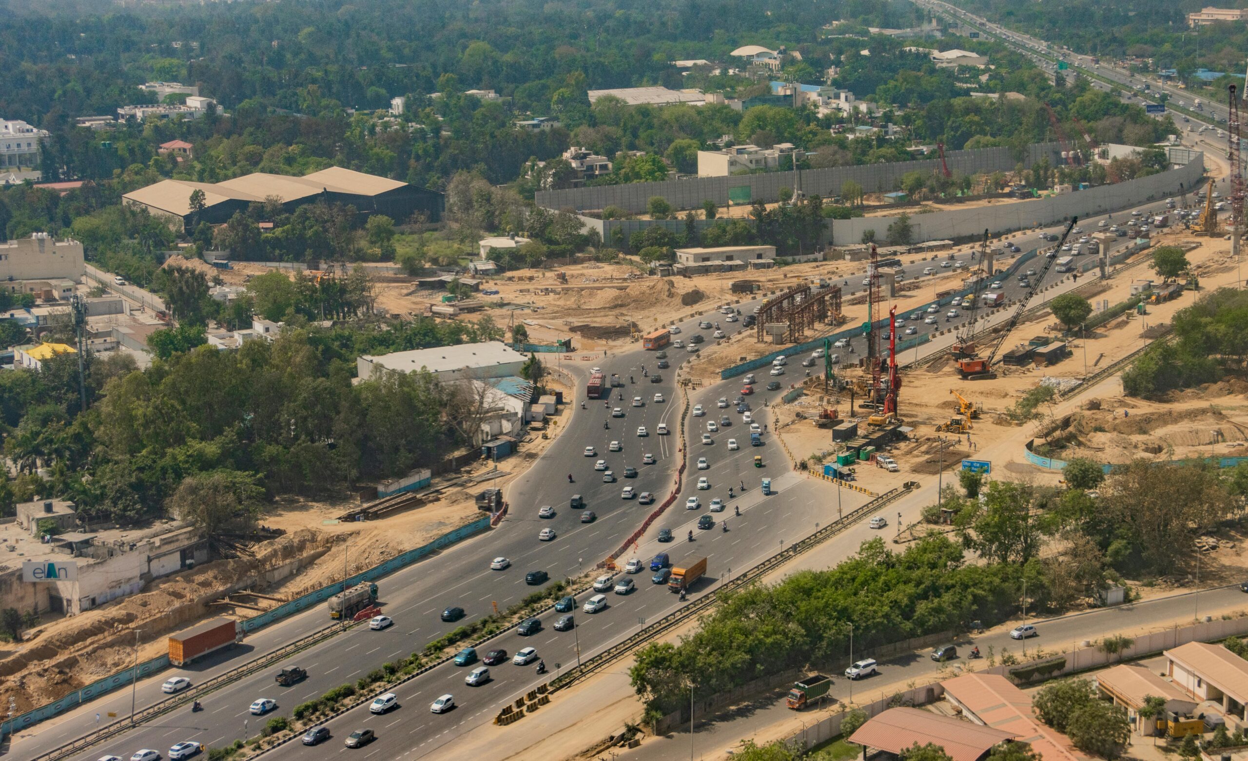 Aerial shot of busy expressway in New Delhi, showcasing traffic and city development.